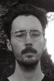 Adam C. Briggs as Eleni's Brother (Age 44) in TS-CAM 2026