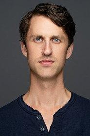 Nikolas Mikkelsen as Street performer / Concert attendee in The Road Home for Christmas 2019