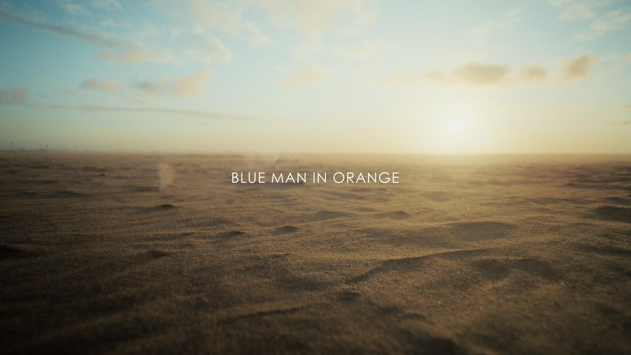 Blue Man in Orange Trailer