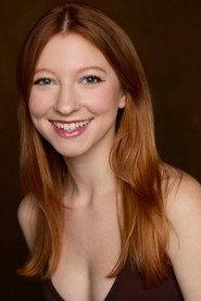 Olivia Fox as Rhea in To Her Beat 2026